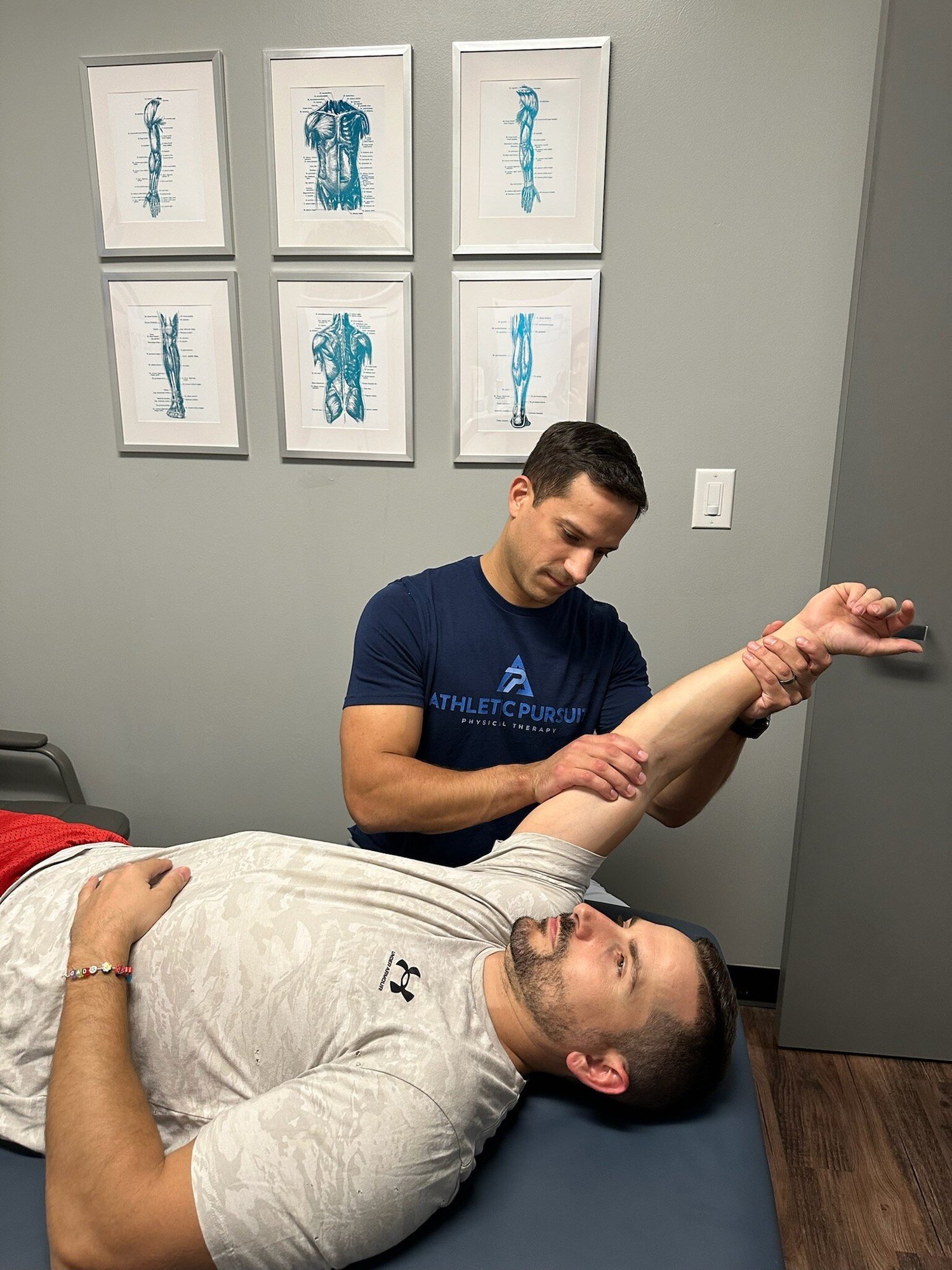 Physical therapist examining patient's shoulder